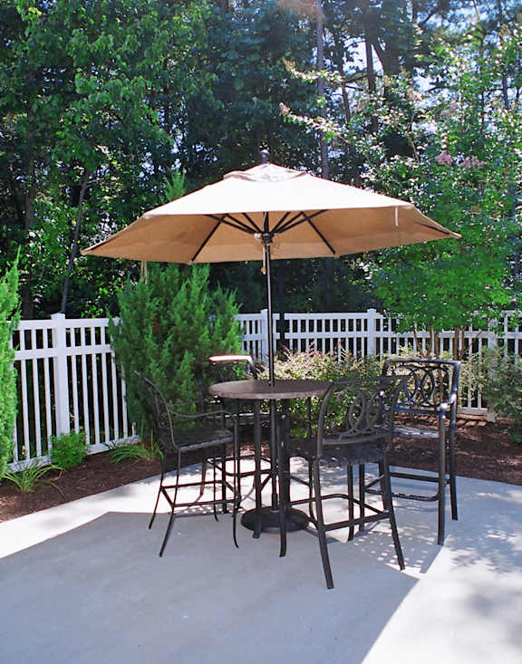 A patio with a table and chairs under an umbrella.