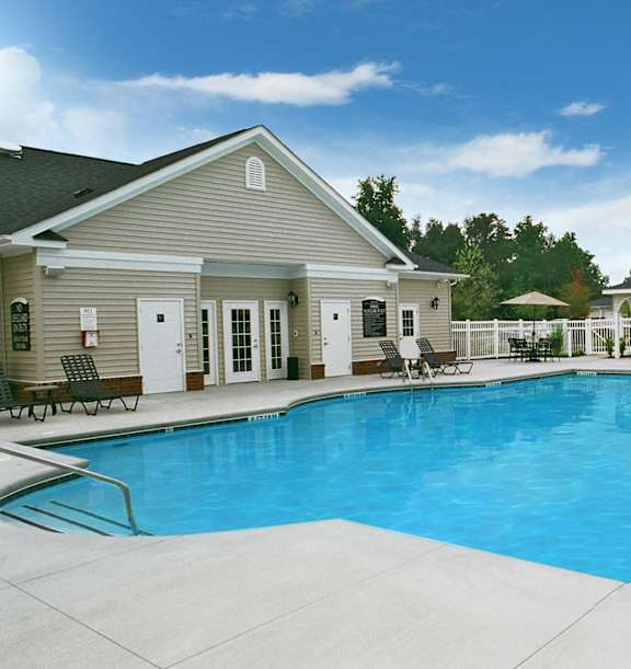 A swimming pool in front of a house.
