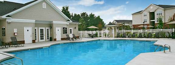 A swimming pool in front of a house.