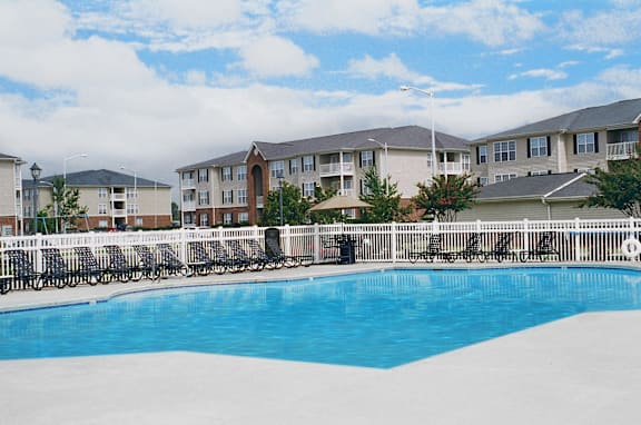 A swimming pool in front of apartment buildings.