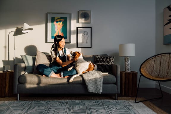 a woman sitting on a couch with her dog