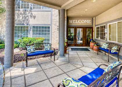 a patio with blue furniture and potted plants
