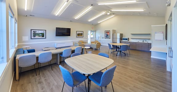 A conference room with a long table surrounded by chairs.