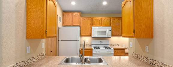 A kitchen with wooden cabinets and a white refrigerator.