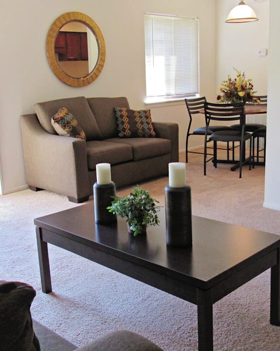 A living room with a couch, chairs, and a coffee table.