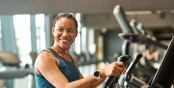 A woman is working out on a treadmill in a gym.