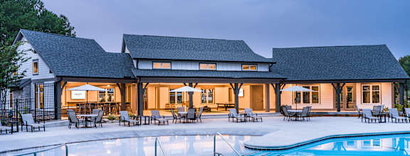 A large house with a pool in front.