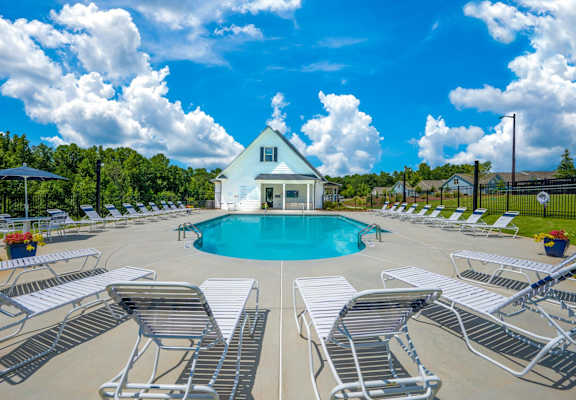 the swimming pool at the retreat at thousand oaks apartments with white chairs around it