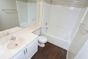 2nd bathroom with dark wood flooring and tub and shower enclosure