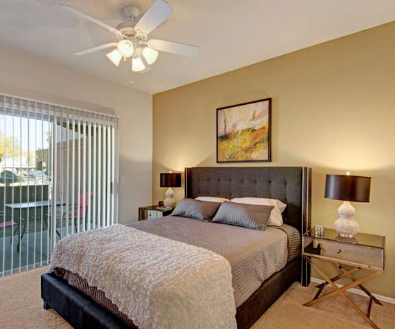A bedroom with a queen-size bed, closet, and nightstands at Dobson Towne Centre. 