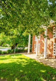 the entrance to a brick apartment building with a porch