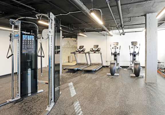 A gym with a variety of equipment including a leg press machine.