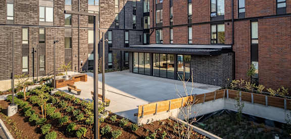 a large brick building with a courtyard in front of it