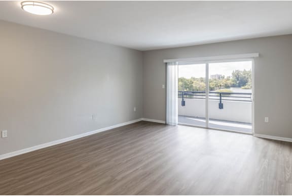an empty living room with a sliding glass door leading to a balcony at Lakeside @ Biscayne Gardens,North Miami, FL,33181
