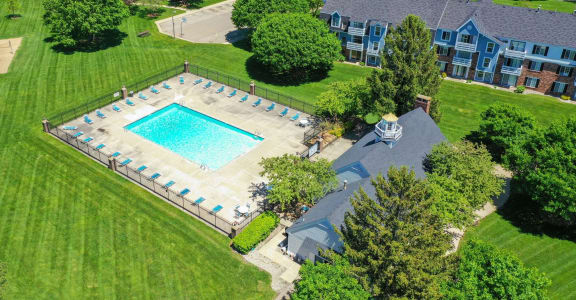 an aerial view of a swimming pool in a yard with a house