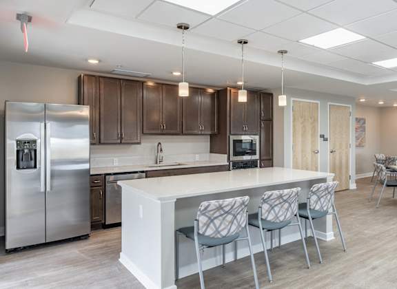 A modern kitchen with a white island and stainless steel appliances.