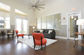 Harbour Cove clubroom with orange and gray seating with dark wood floors