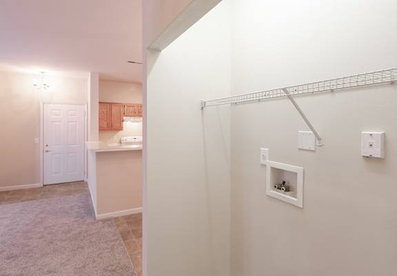 A white wall with a shelf and a white door in the background.