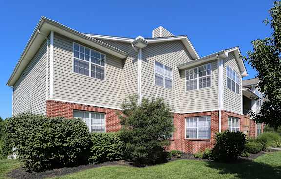 A house with a grey roof and red brick pillars.