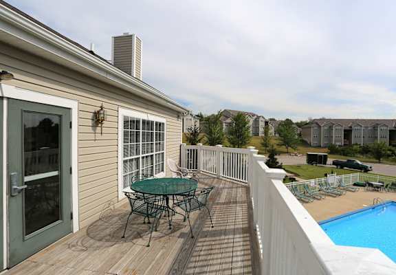 A house with a deck and a table and chairs on it.