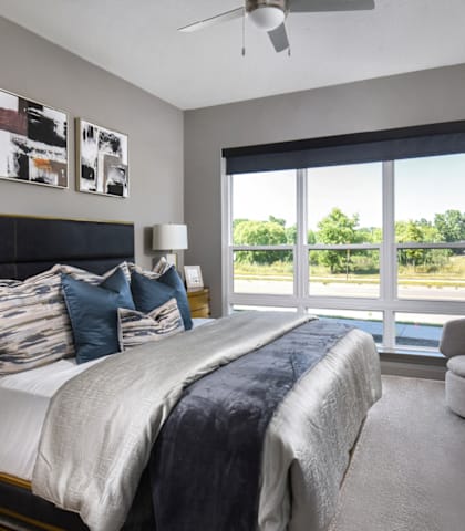 a bedroom with a large window and a large bed