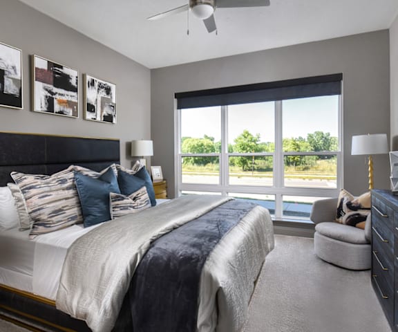 a bedroom with a large window and a large bed