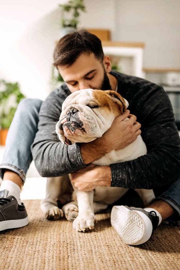 a man sitting on the floor with his dog