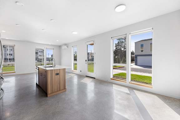 a kitchen with a wooden island in the middle of a room with windows