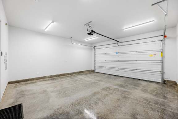 the interior of a garage with a white wall and a garage door
