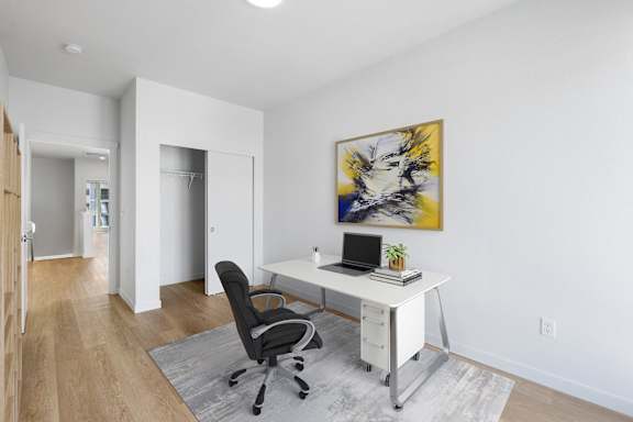 an office with white walls and a white desk with a computer