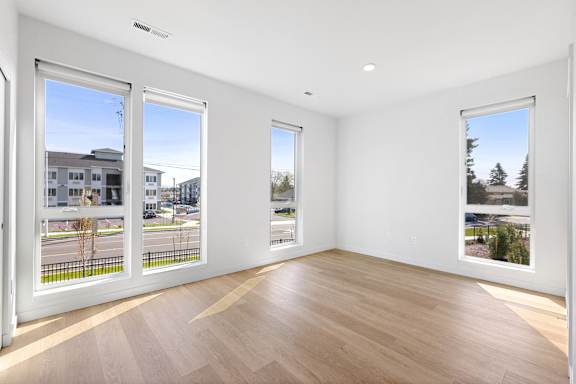 a living room with large windows and a wooden floor