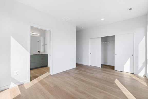 a renovated living room with white walls and wood floors