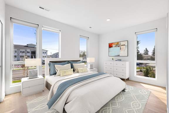 a bedroom with a bed and three windows
