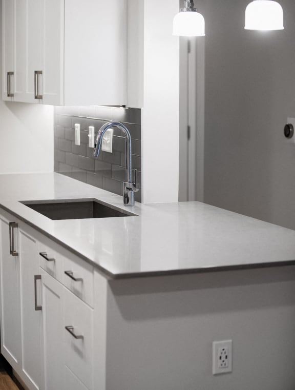 a white kitchen with white cabinets and a sink