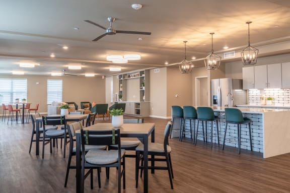 a large dining room with tables and chairs and a kitchen