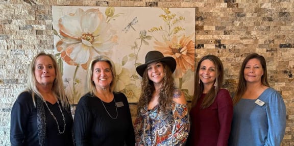a group of women standing in front of a brick wall