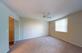 3rd bedroom with beigh carpet, vertical blinds and white ceiling fan