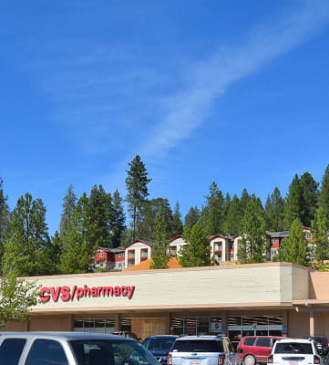 a pharmacy with cars parked in front of it
