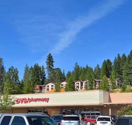 a pharmacy with cars parked in front of it