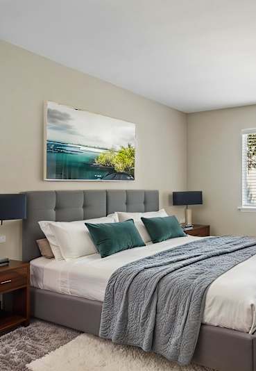 a bedroom with a bed and two windows