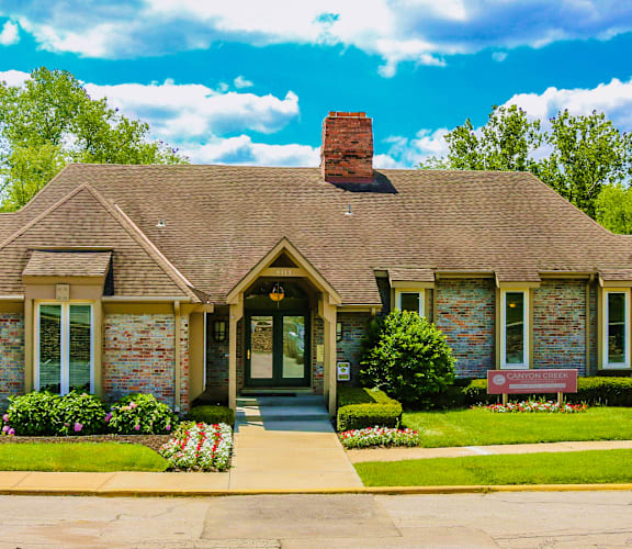 a small brick house with a bench in front of itat Canyon Creek Apartments, Kansas City, MO