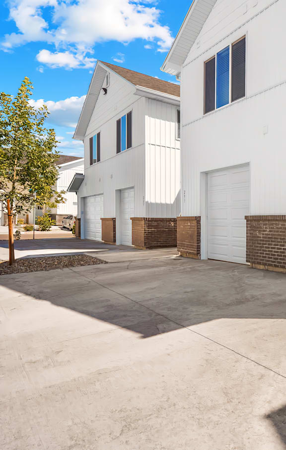 A white house with a garage door open.