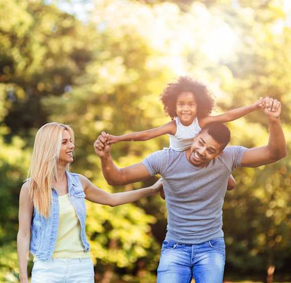A family of three is enjoying a day outdoors in a park.