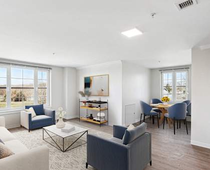 a living room with couches and chairs and a dining room table at Shoreline Grove Apartments in Branford CT.