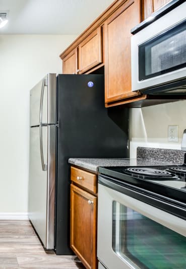 a kitchen with wooden cabinets and stainless steel appliances