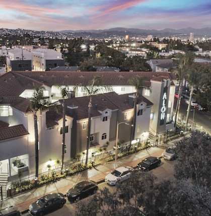 an aerial view of a group of houses with a sunset in the background at Alon Apartments, Los Angeles, CA, 90034