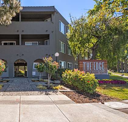 the edge apartments building entrance with sidewalk and trees at The Edge on the Boulevard, California, 94555