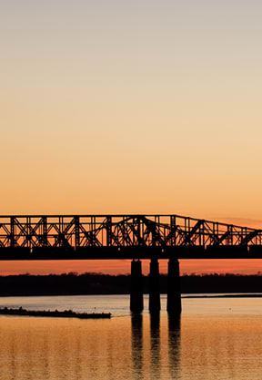 a bridge over a body of water at sunset