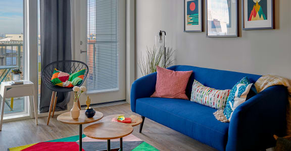 a living room with a blue sofa and colorful pillows