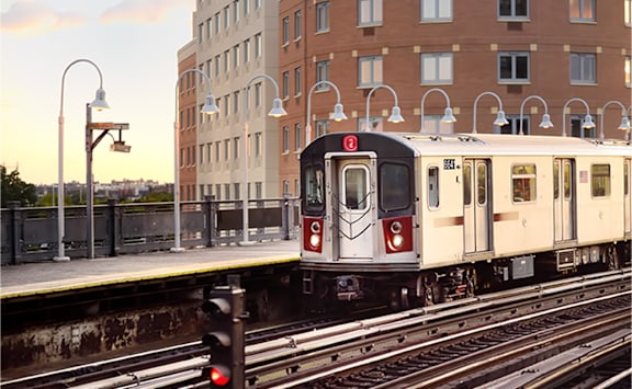 a train on a track with a building in the background